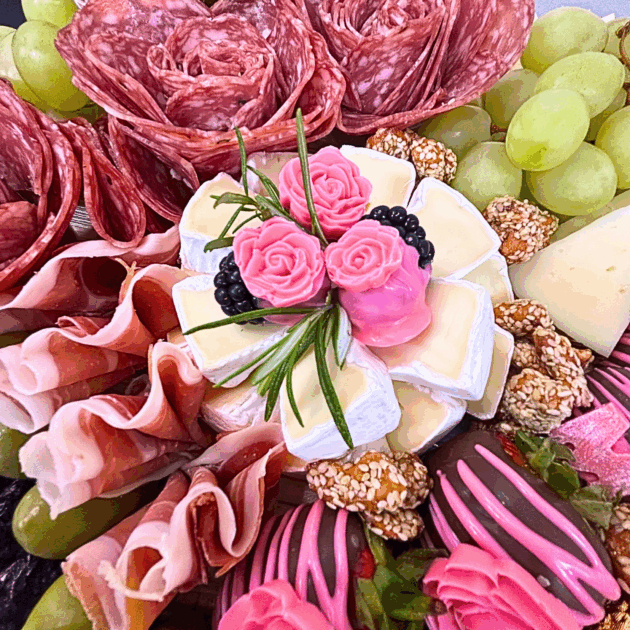 charcuterie board, features an assortment of cured meats, cheeses, fresh grapes